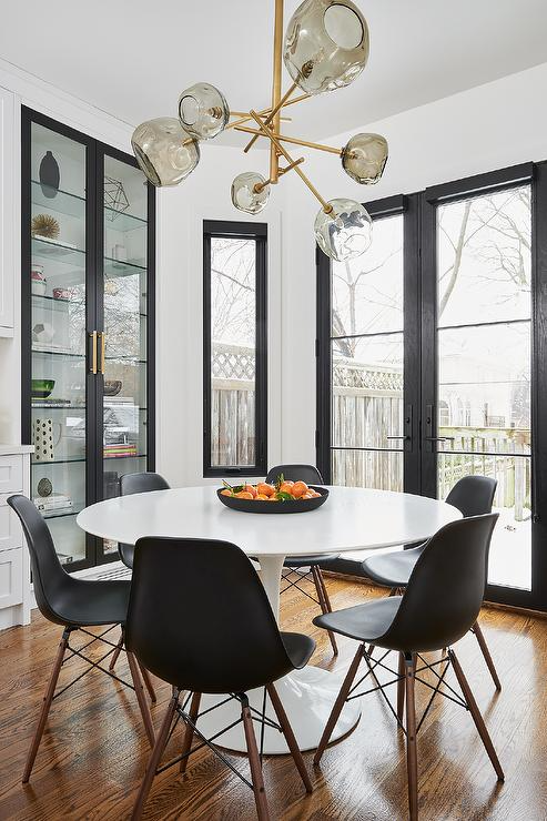 white-tulip-dining-table-with-black-molded-plastic-chairs